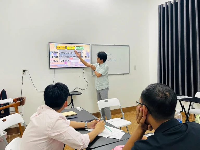 Giáo viên hướng dẫn học viên trên màn hình trong lớp tiếng Anh